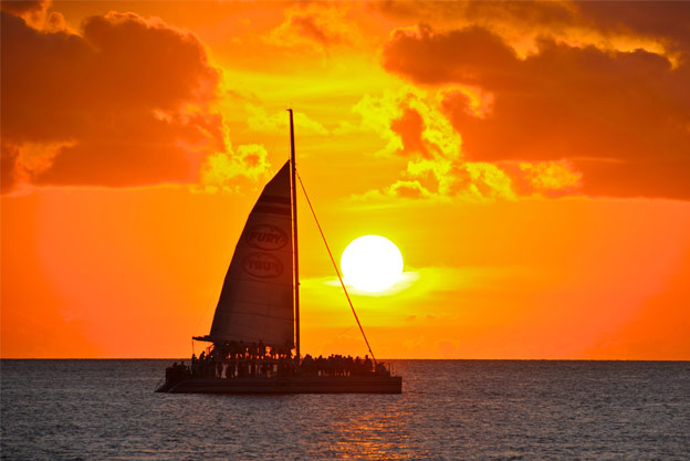 Fury sail boat with beautiful orange sunset in the background in Key West